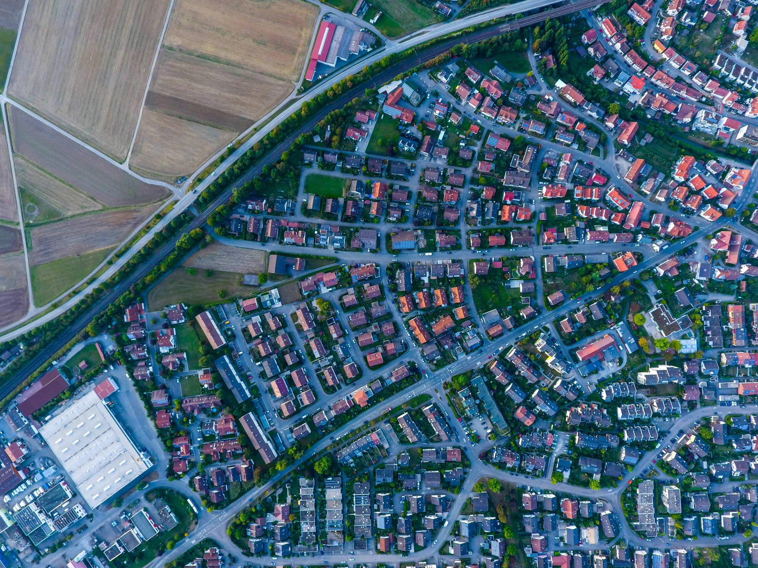Aerial view of a residential neighbourhood showing individual buildings, rooftops, streets and surrounding land.